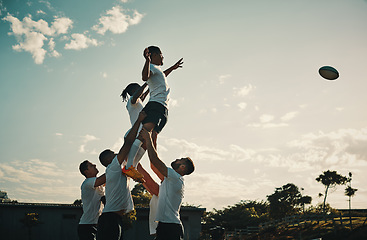 Image showing Rugby, team jump and lift for ball and teamwork, sport and training for game, fitness and exercise or sports performance with blue sky. Group, men and lifting man to catch and professional match