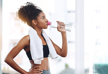 Image showing Fitness, young woman athlete and water or bottle for exercise hydration or after workout with towel and in gym. Bodybuilding, training and wellness or girl runner drink or detox sweat and healthy