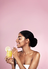 Image showing Woman, healthy orange juice and smile in studio, pink background and mockup for vitamin c benefits. Happy african model, citrus smoothie and fruits for vegan nutrition, diet drink and natural beauty