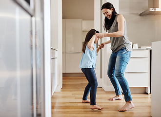 Image showing Holding hands, dance and a child with a mother in the kitchen, bonding and quality time together. Smile, laughing and a mom teaching her daughter with dancing, love and happiness with fun in a house