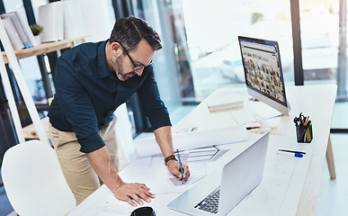 Image showing Corporate, man architect with laptop or computer and sketch in office with notebook at his desk at work. Technology, entrepreneur and male person drawing in plan with pc on table in modern workspace