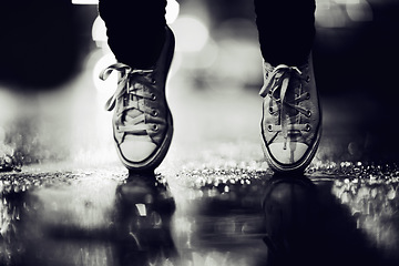 Image showing Balance, shoes or fashion in monochrome on an urban street outdoor for dance or contemporary style. Feet, sneakers or footwear in black and white in a city to explore for travel, tourism or adventure