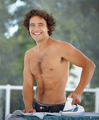 Image showing Happy, portrait and a man ironing a shirt, doing chores and housework in the morning at home. Laughing, handsome and a guy with tools to iron clothes, housekeeping and getting ready with a smile