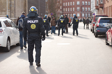 Image showing Safety, riot and protest with police officer in city for law enforcement, protection or security. Brave, uniform and government with person in street for demonstration rally, human rights or activist