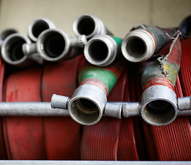 Image showing Fire hose, firefighter or fireman equipment and safety or rescue. Metal or steel tools, behind the scenes of workplace and closeup of emergency red water pipes or gear for buildings and protection