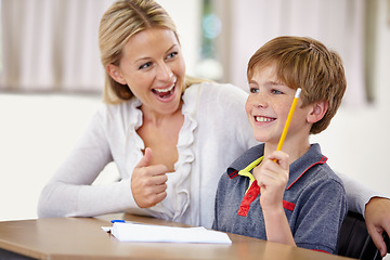 Image showing Thumbs up, happy teacher with student in classroom in school and teaching. Correct or success, education or learning and female educator helping male child with homework or question at desk.