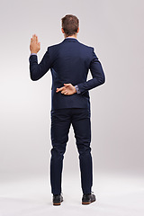 Image showing Back of businessman, taking an oath and fingers crossed in a white background. Legal or court, cheat or corruption and dishonest man or liar with suit in studio backdrop with hand gesture for a lie