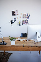 Image showing Empty office, computer desk and small business startup of interior or online marketing studio. Photo wall with desktop PC and notebook with lamp on table for creativity in a clean modern workspace