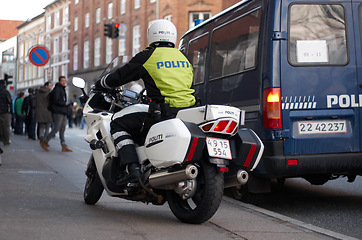 Image showing Emergency, motorbike and city safety police officer working for protection and peace in an urban town in Denmark. Security, law and legal professional or policeman on a motorcycle ready for service