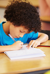 Image showing Boy kid, school and writing test in classroom with focus, concentration or thinking for education goals. Male child, book and pen in class for assessment, studying or learning at desk for development