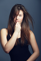 Image showing Portrait, beauty and woman with hair care, volume and confident model against a dark studio background. Face, female person and girl with texture, cosmetics and hairstyle with growth and treatment