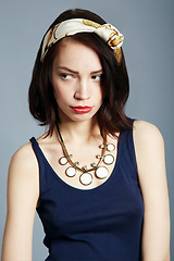 Image showing Face, woman in vintage fashion with attitude or moody, frown or frustrated pose on studio background. Model, girl and upset or tired expression in retro clothing and style, magazine or beauty