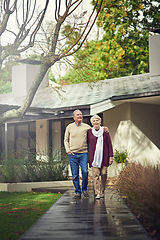 Image showing Love, outdoor and elderly couple walking by their house for wellness, fresh air and bonding. Happy, retirement and senior man and woman on a path together in their garden at their modern home.