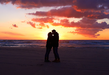 Image showing Kiss, silhouette people together at sunset and on seaside together for honeymoon. Care or love, holiday and shadows of couple on the beach or sea for romantic date outdoor on summer vacation