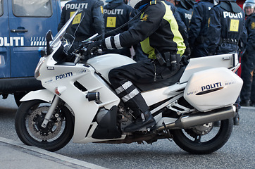 Image showing Emergency, road and motorcycle police officer working for protection and peace in an urban town in Denmark. Security, traffic and legal professional or policeman on a motorbike ready for service