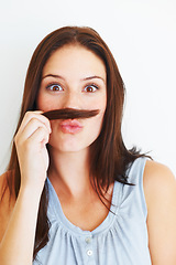 Image showing Comic, portrait and a woman with hair moustache isolated on a white background in studio. Smile, funny and a young girl being crazy, making face and playing with hairstyle for comedy on a backdrop