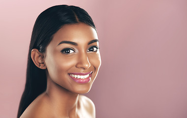 Image showing Face portrait, skincare and smile of woman in studio isolated on a pink background mockup. Natural, beauty and Indian female model with makeup, cosmetics and spa facial treatment for healthy skin.