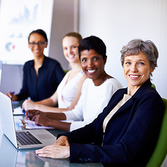 Image showing Portrait, corporate team and women in a meeting at office with a laptop for workshop or planning. Face of senior woman or leader happy about teamwork, group diversity and collaboration at table