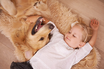 Image showing Girl, dog and hug together on floor in living room and golden retriever, kid and relaxing with pet on lounge carpet. Young child, Labrador and bonding in family home, pets and dogs with children