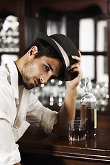 Image showing Portrait, whisky and a man sitting at the bar drinking alcohol in a glass while alone or feeling unhappy. Brandy, drink and beverage with a handsome young male pub customer at a wooden counter