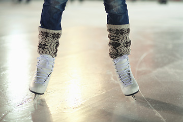 Image showing Ice skates, woman shoes and legs of skater training, recreation and skate on frozen floor, arena or stadium. Winter, entertainment and feet of female person balance, active or learning figure skating