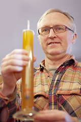 Image showing Beer, brewing and glass tube with a man in a plant, factory or warehouse for the production of alcohol. Manufacturing, industry and career with a male brewer in a distillery for quality control