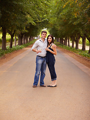 Image showing Couple, portrait and wine outdoor at a vineyard for vacation, holiday or travel with love and care. Man and a woman hug on a countryside road with trees, alcohol glass or drinks to celebrate marriage