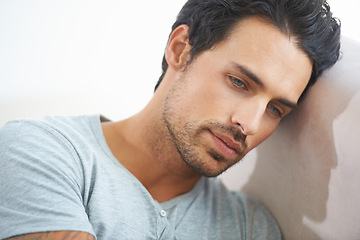 Image showing Face, male model and depression or sad, mindful and head on wall while isolated on studio white background. Mental health, stress and tired man thinking of problem or suffering in silence of failure