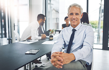 Image showing Corporate, portrait and mature businessman in meeting or conference and sitting in boardroom with his coworkers. Mentor, manager and senior man with his team in office planning together in workplace