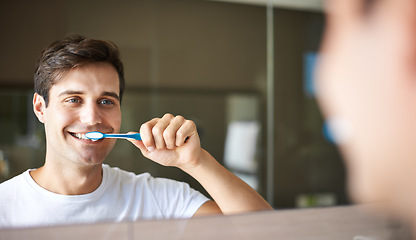 Image showing Brushing teeth, man and cleaning in a bathroom at home for oral hygiene and health. Smile, dental and toothbrush with a male person with happiness in the morning at a house with mirror reflection