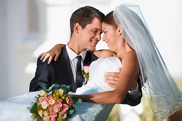 Image showing Wedding, marriage or carry with a bride and groom in celebration outdoor as a newlywed married couple. Smile, romance and tradition with a man carrying a woman over the threshold after a ceremony