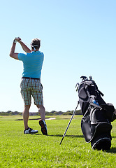 Image showing Swing, golf and behind man with driver on a field for training, hobby and sports on blue sky background. Club, swinging and rear view of male golfer on field for fitness, match or sports practice