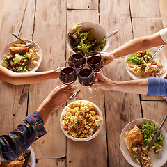 Image showing Hands, toast with wine glasses and food with cheer for celebration at lunch. Top view of event, congratulations or success and friends or family sharing a meal or dish together at table with drinks