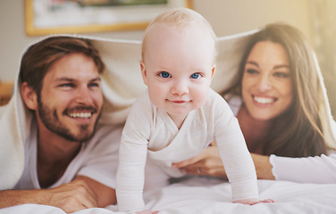 Image showing Baby, mother and father playing with blanket in bedroom for love, care and quality time together. Portrait of cute newborn child with parents, happy family and relax with bedding over heads at home