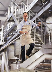 Image showing Factory, portrait and male wine maker standing on the stairs in a production warehouse. Success, smile and full length of a man winery employee working in alcohol manufacturing cellar on a vineyard.