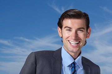 Image showing Portrait, smile and happy man outdoors for business travel against a blue sky background. Face, empowered and businessman person excited while traveling, laughing and cheerful, confident and free