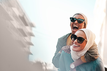 Image showing Muslim women, friends and piggyback in city with mockup space, travel and comic adventure together. Islamic woman, happiness and walking in metro cbd with funny game, sunglasses and bond on journey