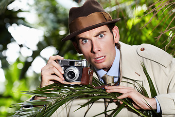 Image showing Retro spy man, camera and jungle for investigation, inspection or journalist with shock at job. Private investigator, secret photographer and retro paparazzi in trees, bush or leaves for surveillance