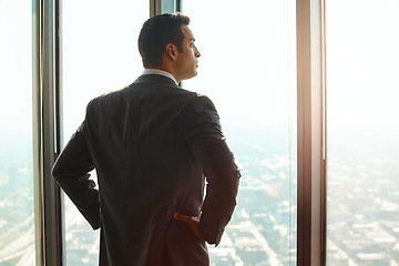 Image showing Business man, office window and thinking of ideas, plan or vision with cityscape. Professional male executive with hands on hips for opportunity, dream and future corporate development from behind