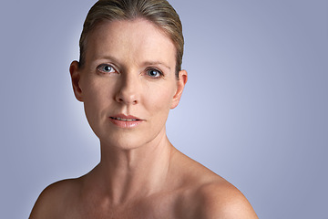 Image showing Face, beauty and portrait of mature woman doing cosmetic skincare facial isolated in a blue studio background. Cosmetics, care and old female model calm with natural skin due to anti aging