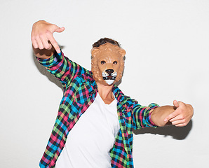 Image showing Animal mask, hand gesture and a man in studio with cool attitude to party with a positive mindset. Lion face or male model person isolated on a white background for fun, funny and goofy portrait