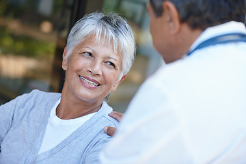 Image showing Senior, smile and woman talking to her doctor, consultation or conversation. Consulting, medical professional and female person in discussion with healthcare physician for health, wellness or checkup