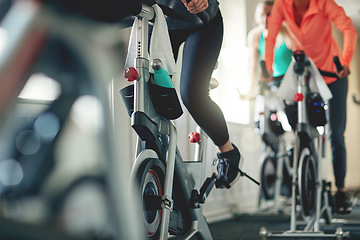 Image showing Fitness, legs and exercise bike with people in a gym for a cardio or endurance spinning class workout. Health, wellness and energy with a sporty athlete group training or cycling in a sports center