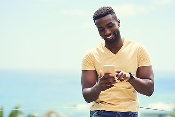 Image showing Black man, phone and typing on social media, app or text and message, communication and mockup blue sky background. Smartphone, online networking or internet conversation on screen with smile