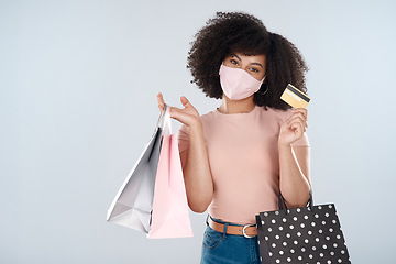 Image showing Woman, face mask and shopping bags with credit card portrait for fashion, sale or discount deal. Female person or customer with a retail bag for promotion offer in studio space and white background