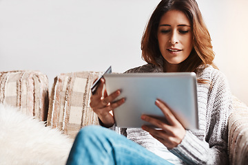 Image showing Internet, tablet and credit card with an ecommerce woman on a sofa in the living room of her home. Online shopping, finance and fintech payment with a young female online customer in her house
