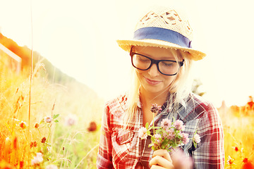Image showing Lens flare, countryside and woman with flowers in field for freedom, wellness and fresh air outdoors. Nature, summer and happy female person in natural meadow for relaxing, calm and peace in morning