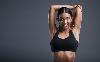 Image showing Portrait, mockup and stretching with an athlete woman in studio on a gray background for fitness or health. Exercise, workout and warm up with an attractive young female model training her body