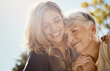 Image showing Family, love or smile with a senior mother and daughter bonding outdoor together during a summer day. Happy, flare and retirement with a young man hugging her elderly parent outside in the park