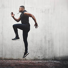 Image showing Jump, fitness and black man running, speed and energy for cardio training, workout and sports wellness or body health. Athlete, runner or person exercise on concrete wall, action run or moving in air